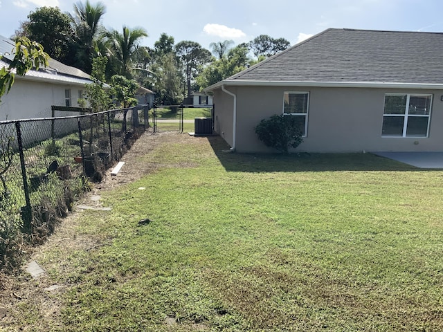 view of yard featuring fence, central AC unit, and a patio