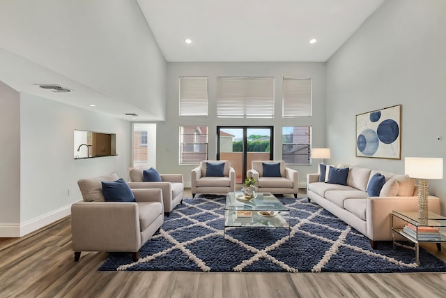 living room with wood-type flooring and a high ceiling