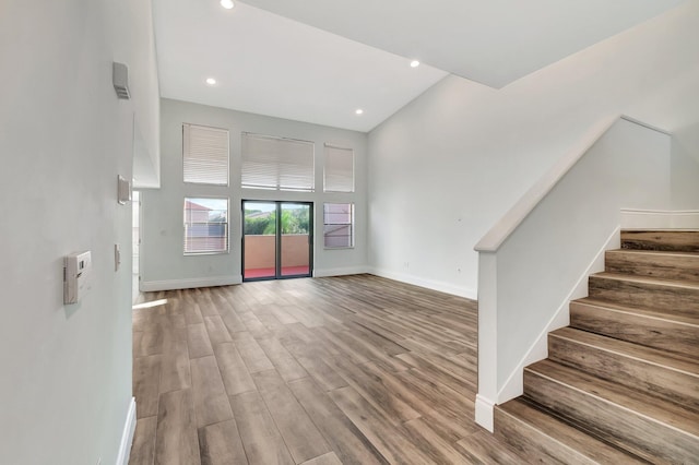 interior space with light wood-type flooring and a towering ceiling