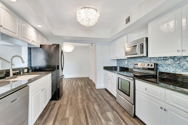 kitchen featuring a notable chandelier, sink, white cabinetry, and stainless steel appliances