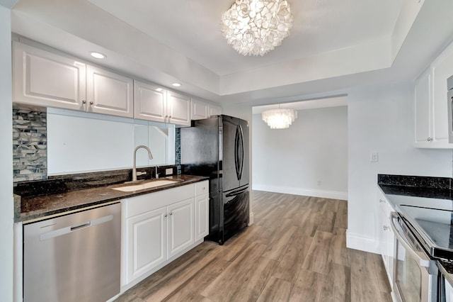 kitchen featuring stainless steel dishwasher, a notable chandelier, white cabinets, and hanging light fixtures