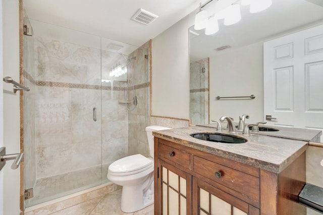 bathroom with vanity, a shower with shower door, tile patterned floors, and toilet