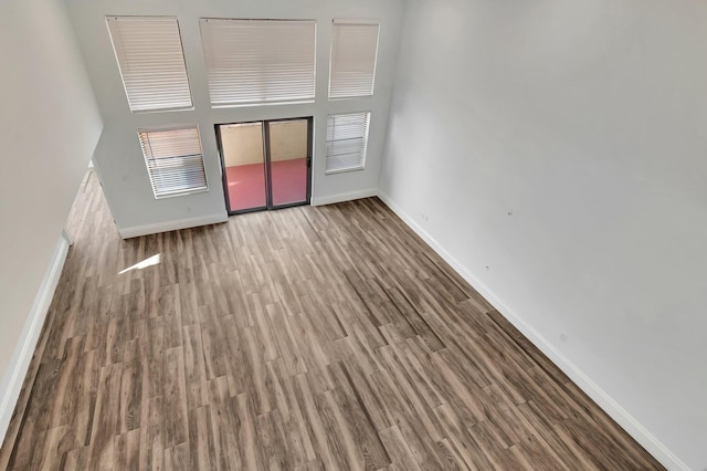 interior space with a towering ceiling and wood-type flooring