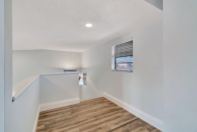 stairway with hardwood / wood-style flooring and a textured ceiling