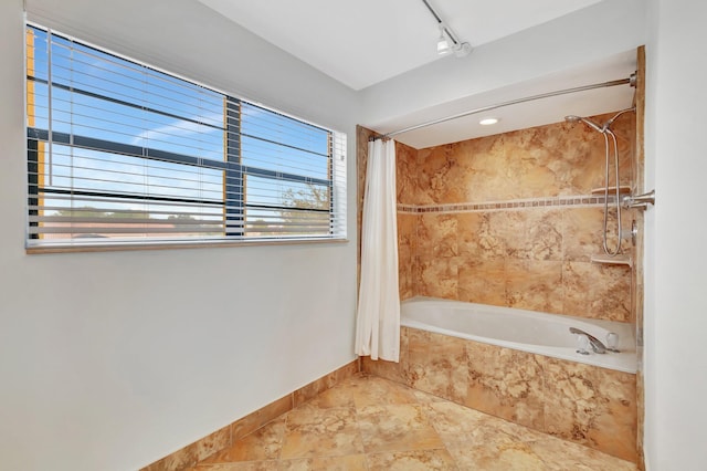 bathroom with shower / bath combo with shower curtain and track lighting