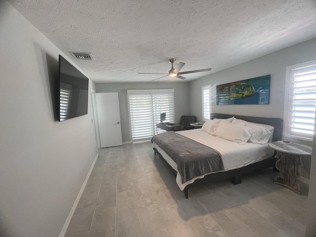 bedroom featuring a textured ceiling, light hardwood / wood-style flooring, and ceiling fan