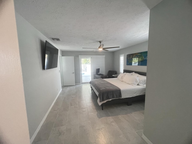 bedroom featuring a textured ceiling, access to outside, ceiling fan, and light hardwood / wood-style floors