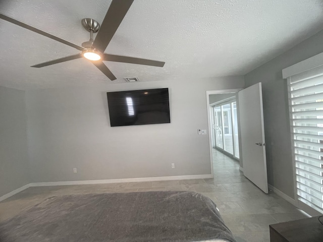 empty room with a textured ceiling and ceiling fan