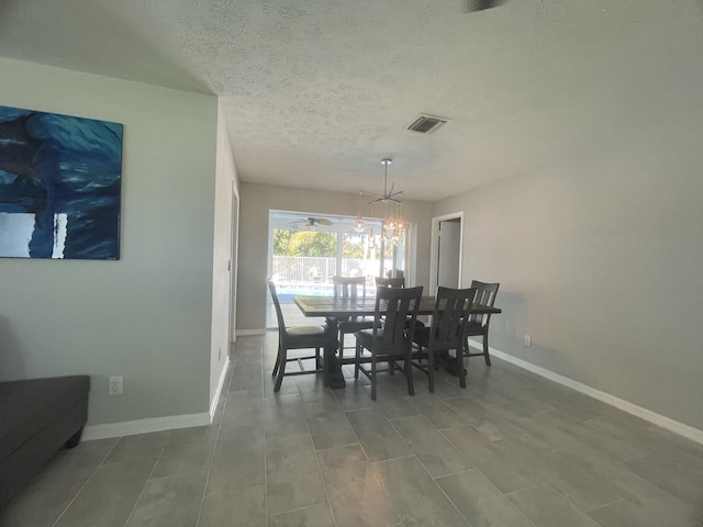 dining room featuring a textured ceiling and a notable chandelier