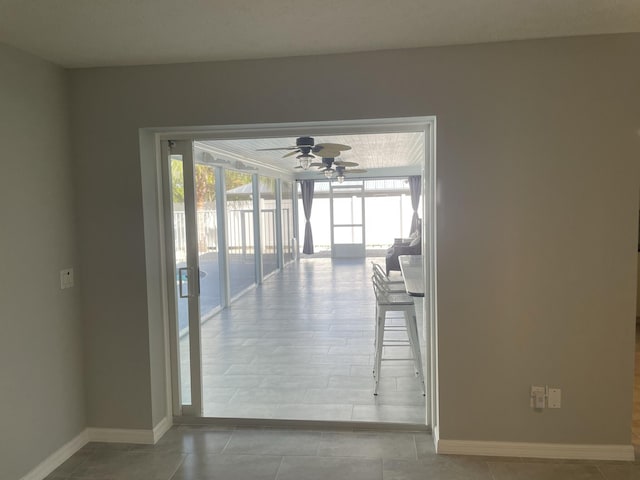 tiled spare room featuring plenty of natural light and ceiling fan