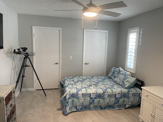 bedroom with ceiling fan and a textured ceiling