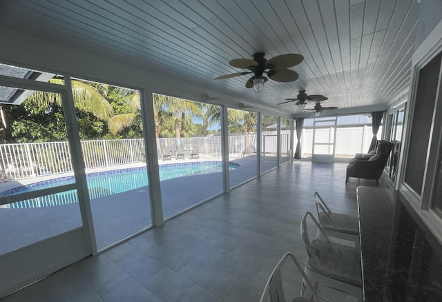 unfurnished sunroom featuring ceiling fan and wooden ceiling