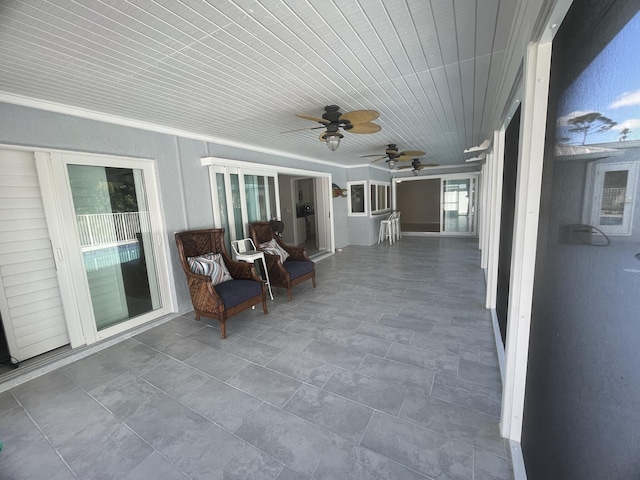 unfurnished sunroom featuring ceiling fan and wooden ceiling