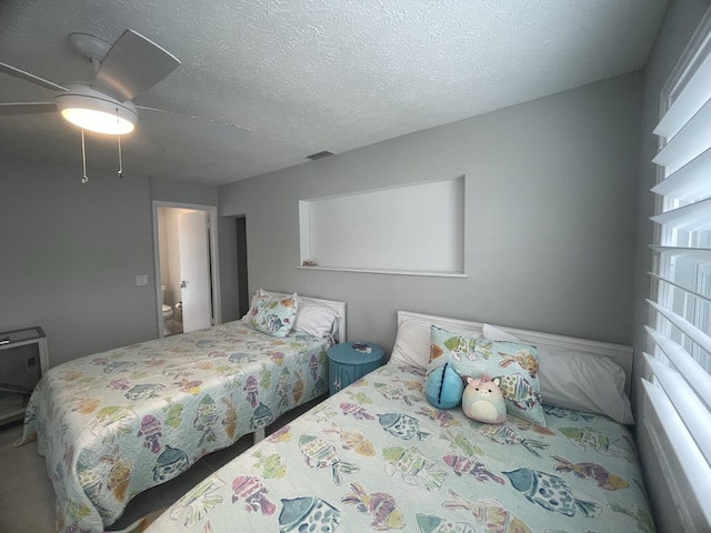 bedroom with ceiling fan and a textured ceiling