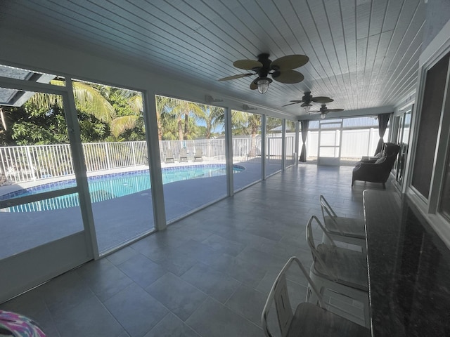 unfurnished sunroom with a wealth of natural light, wooden ceiling, and ceiling fan