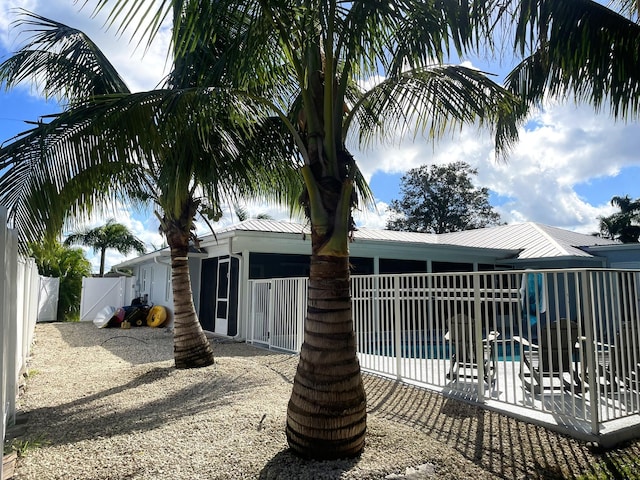 rear view of house featuring a fenced in pool