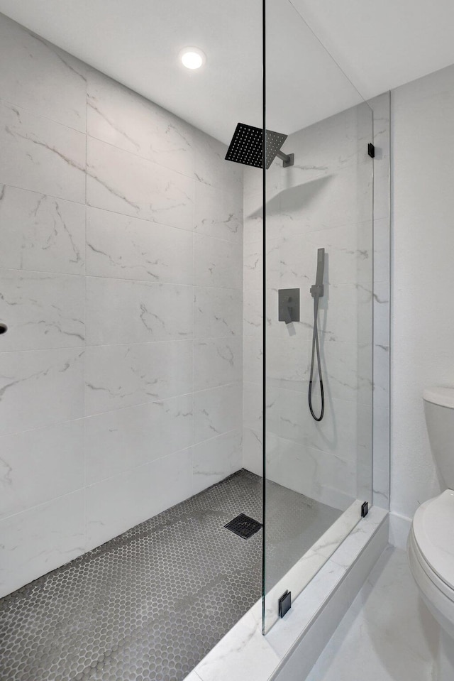 bathroom featuring toilet and a tile shower