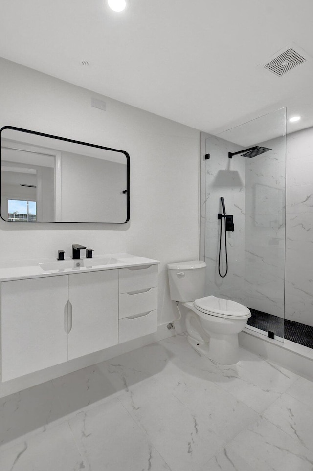 bathroom featuring vanity, toilet, and a tile shower