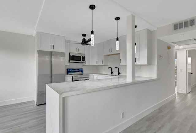 kitchen featuring ceiling fan, stainless steel appliances, kitchen peninsula, light hardwood / wood-style floors, and white cabinets