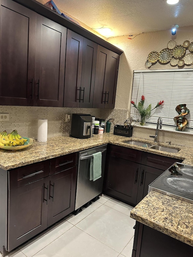 kitchen featuring dark brown cabinetry, light stone countertops, dishwasher, and sink