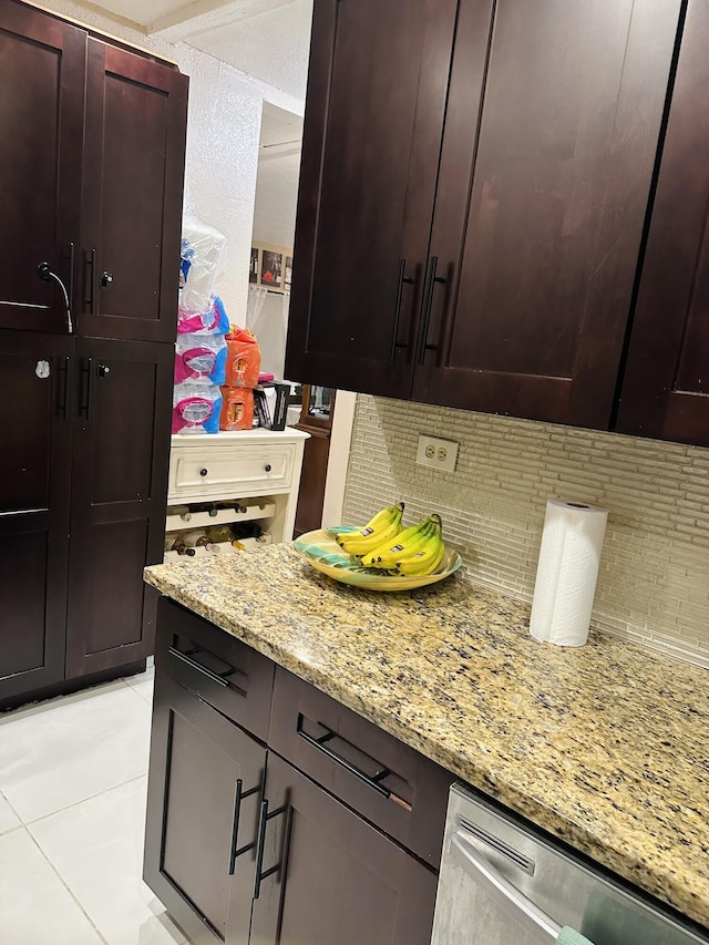 kitchen with dishwasher, light stone counters, and light tile patterned flooring