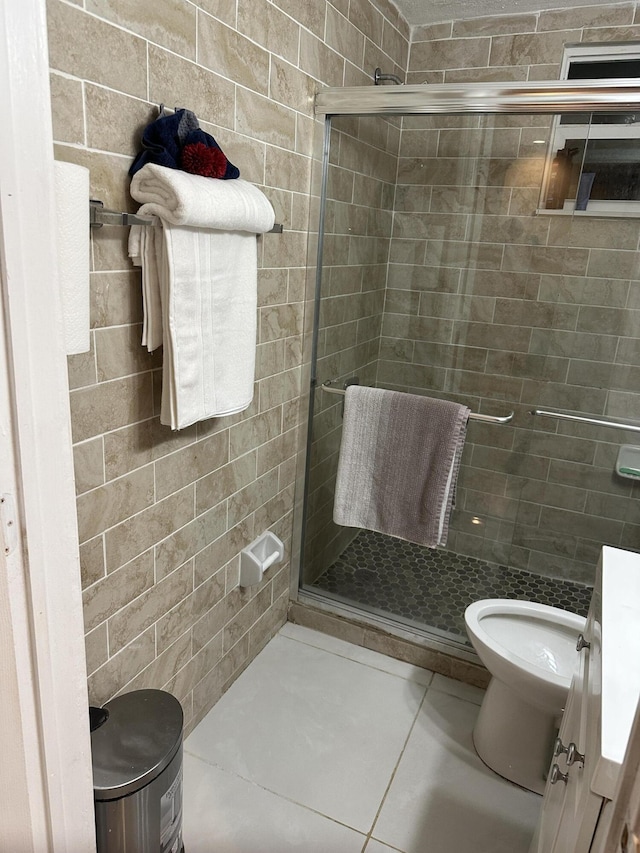 bathroom with toilet, vanity, tile patterned floors, and a shower with door