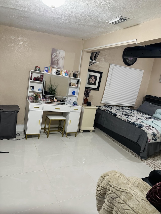 bedroom with light tile patterned floors and a textured ceiling