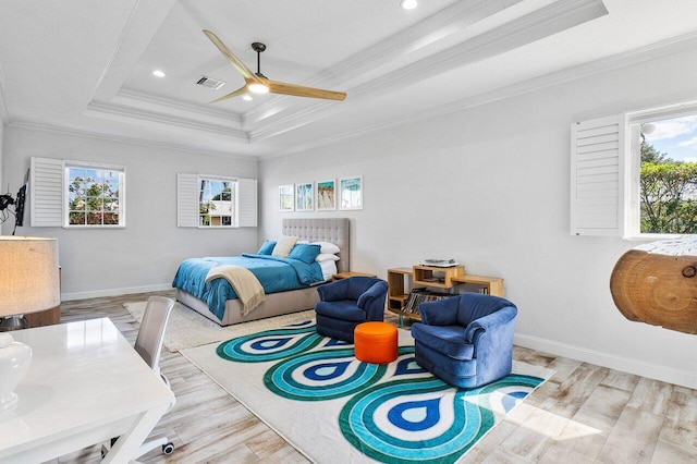 bedroom featuring ceiling fan, a tray ceiling, ornamental molding, and light hardwood / wood-style floors