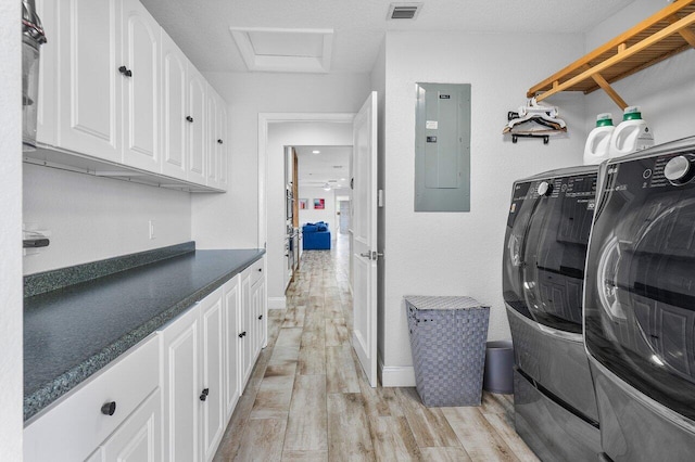 clothes washing area with cabinets, separate washer and dryer, light hardwood / wood-style floors, and electric panel