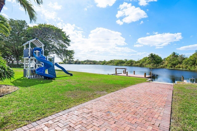 exterior space with a playground, a water view, and a yard