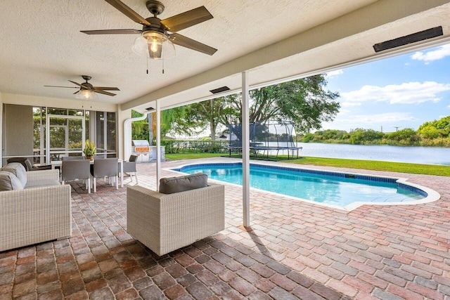 view of pool featuring ceiling fan, a water view, outdoor lounge area, and a patio