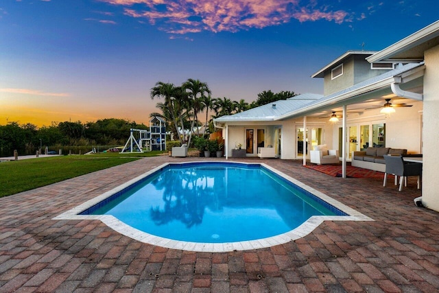 pool at dusk featuring ceiling fan, a patio area, a playground, an outdoor hangout area, and french doors