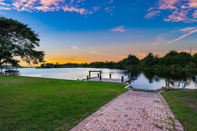 dock area with a water view and a yard