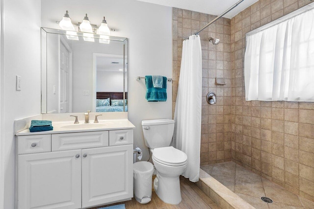 bathroom with toilet, a wealth of natural light, vanity, and curtained shower