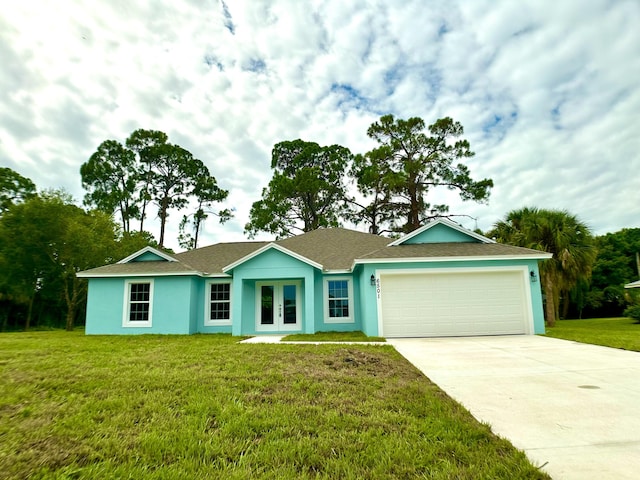 ranch-style house featuring a front yard, french doors, and a garage