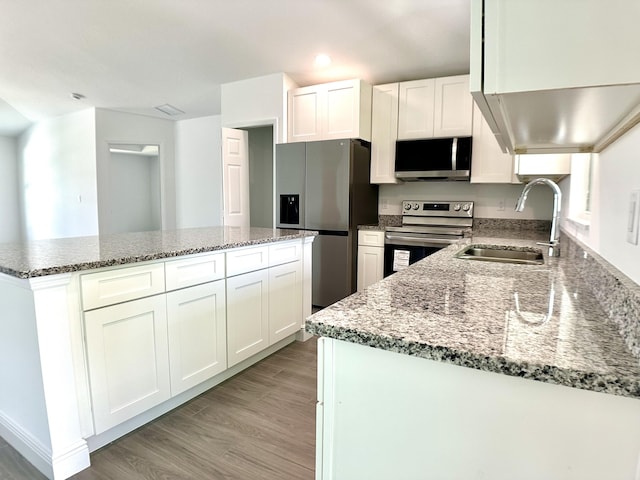 kitchen with light stone countertops, sink, stainless steel appliances, light hardwood / wood-style floors, and white cabinets