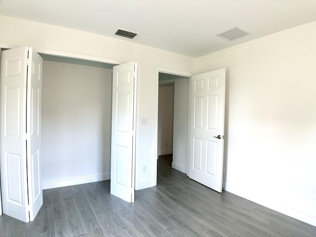 unfurnished bedroom with dark hardwood / wood-style floors