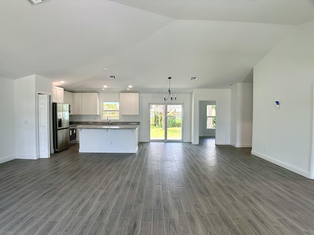 kitchen featuring dark wood-type flooring, stainless steel fridge, decorative light fixtures, a kitchen island, and white cabinetry