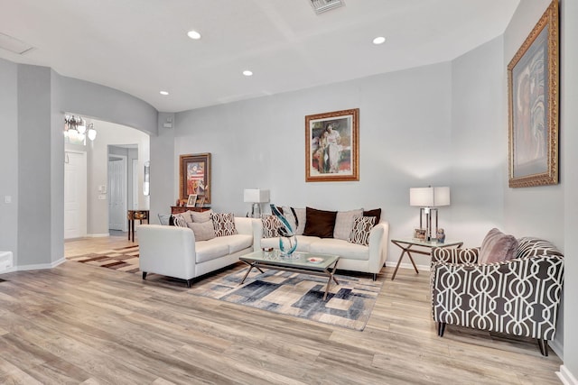 living room featuring light hardwood / wood-style flooring and a notable chandelier