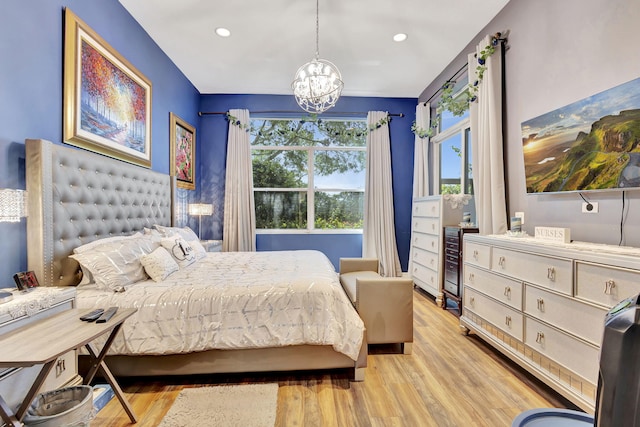 bedroom with light hardwood / wood-style flooring and an inviting chandelier