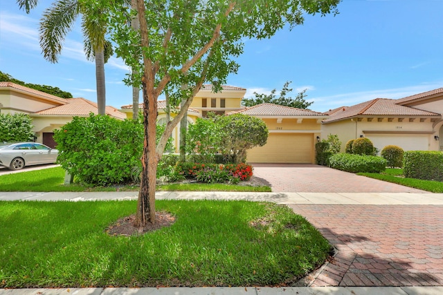 mediterranean / spanish house featuring a front yard and a garage