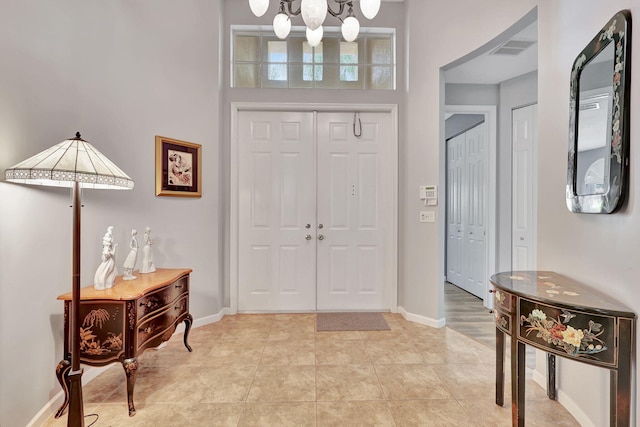 entrance foyer featuring a chandelier and a towering ceiling