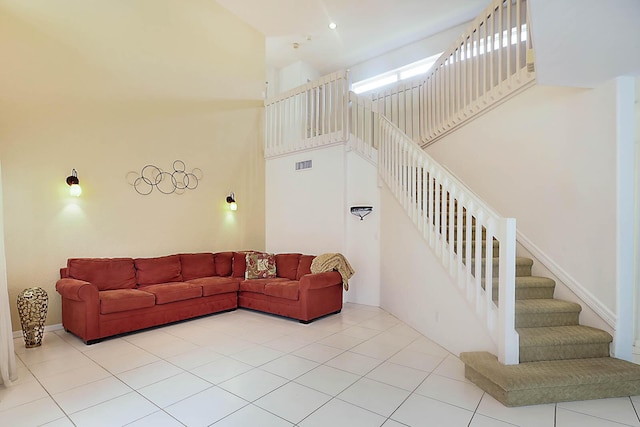 living room with light tile patterned floors and a high ceiling