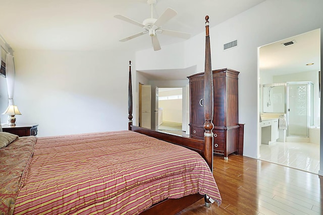 bedroom with ensuite bathroom, light hardwood / wood-style flooring, and ceiling fan