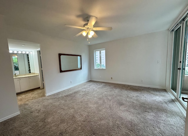 unfurnished bedroom with ensuite bath, ceiling fan, and light carpet