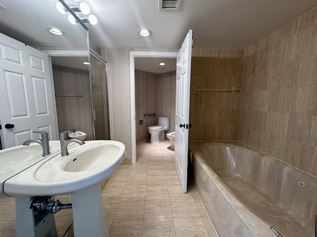 bathroom featuring tiled tub, toilet, and a bidet