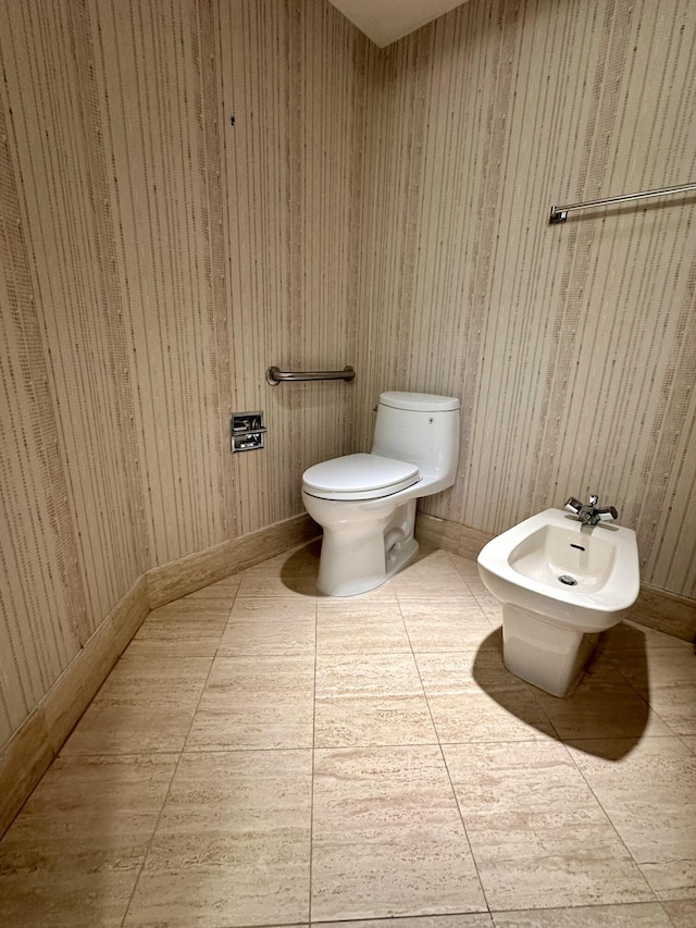 bathroom with toilet, a bidet, and wood walls