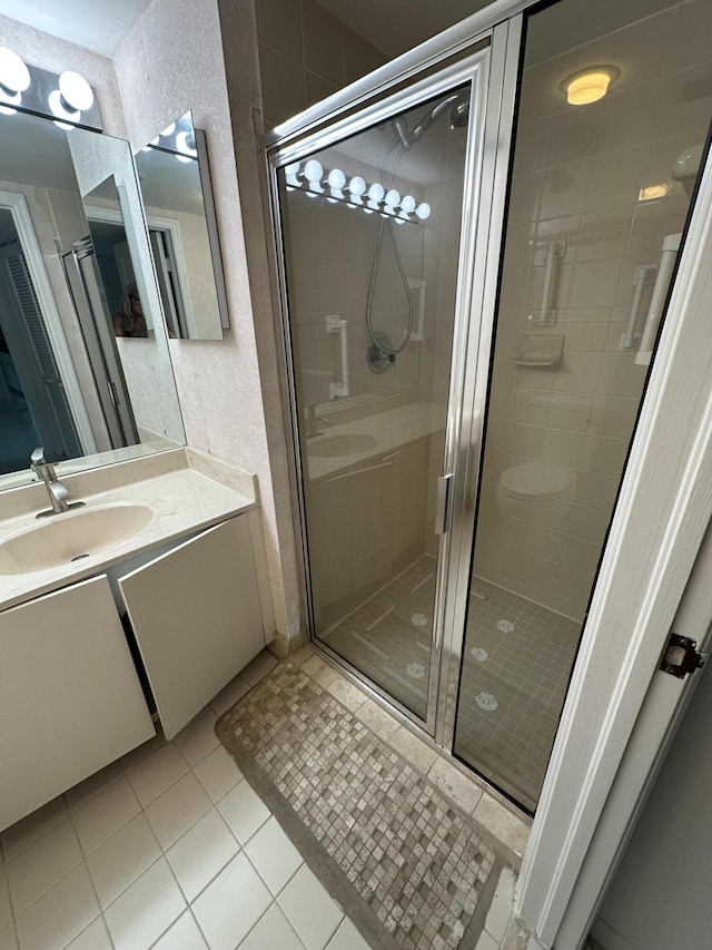 bathroom featuring tile patterned flooring, vanity, and walk in shower