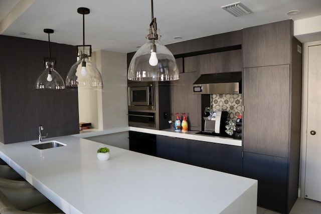 kitchen featuring sink, stainless steel microwave, tasteful backsplash, oven, and extractor fan