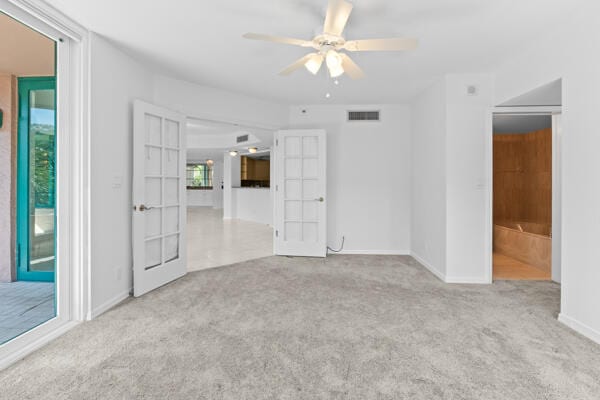 spare room featuring light colored carpet and ceiling fan
